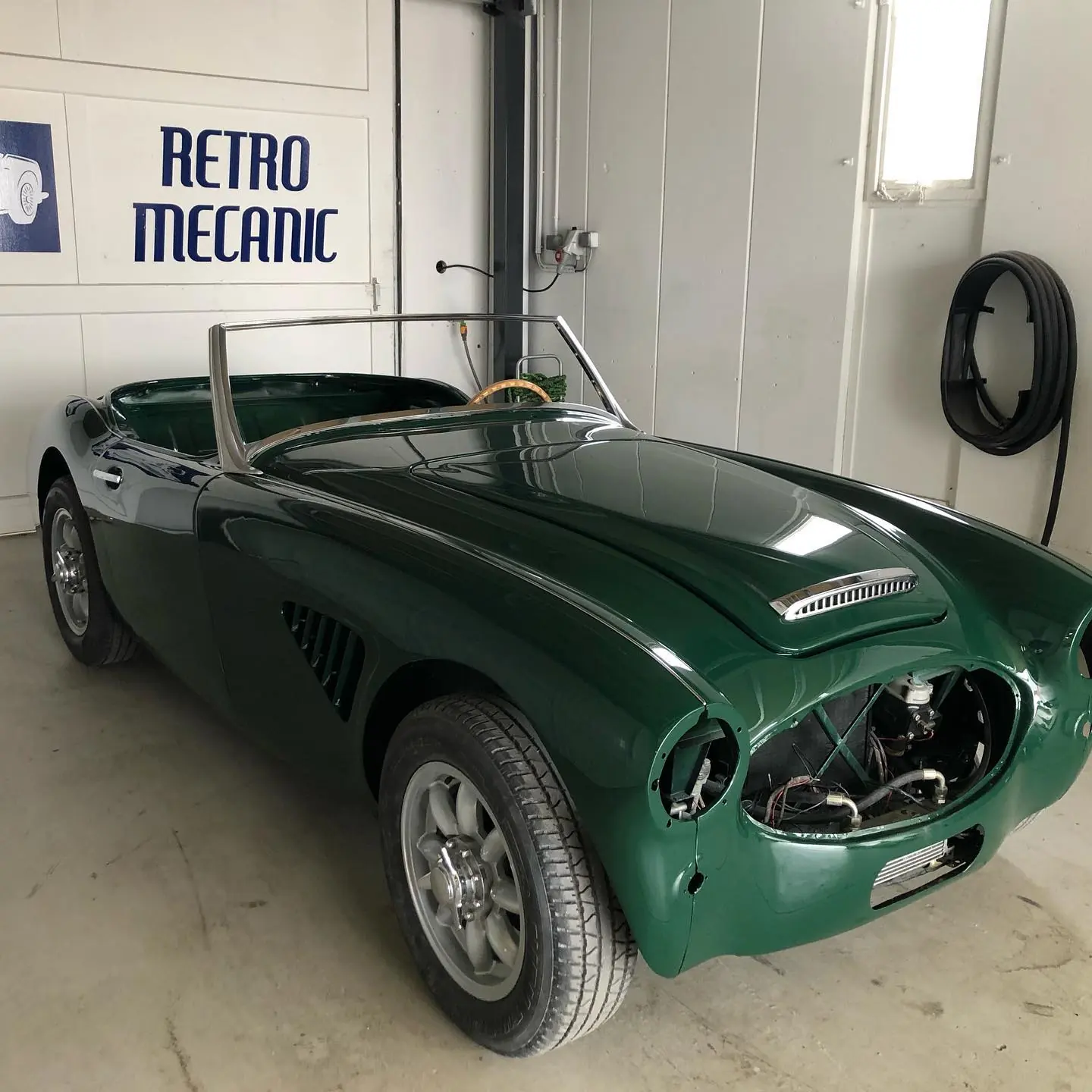 Austin-Healey verte en cours de finition dans l'atelier Retro Mecanic