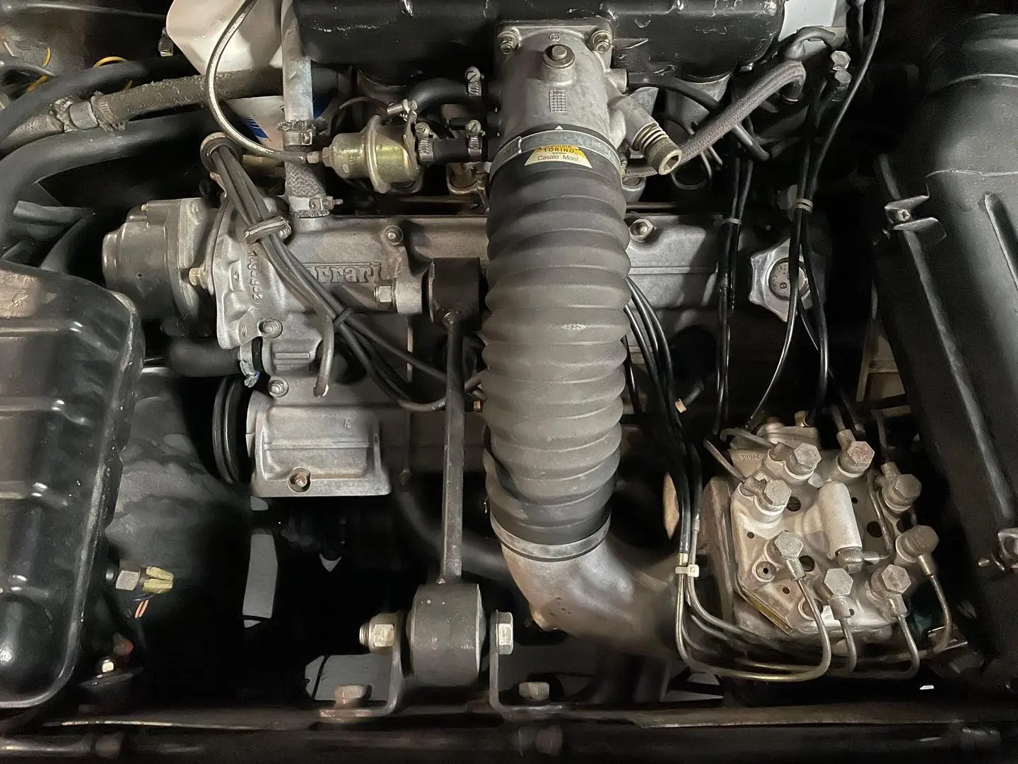 Compartiment moteur d'une Ferrari remis en état : collecteur, tuyauterie et pompe d'injection