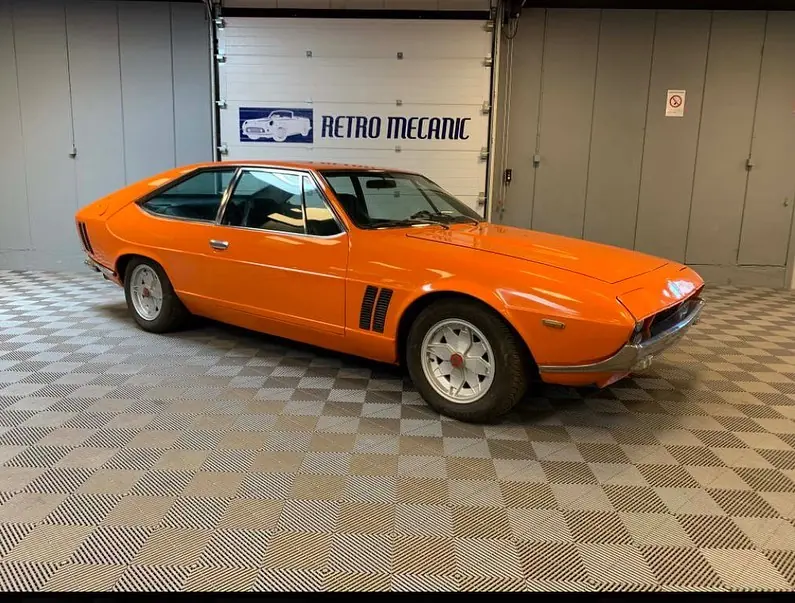 Coupé italien orange à roues alliage, dans le hall Retro Mecanic (Iso Rivolta)